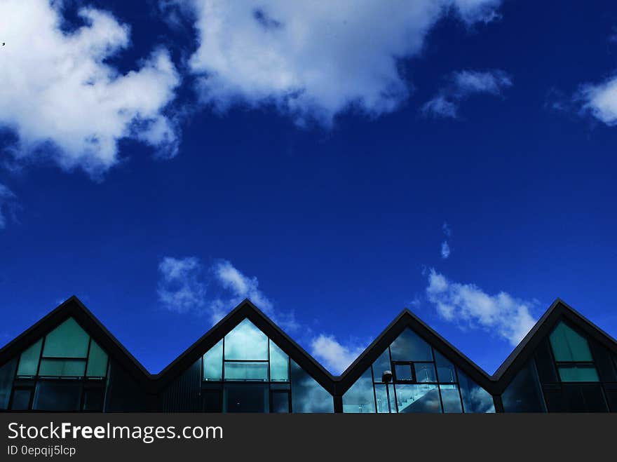 Grey Wood and Glass House Under Blue Sky and Clouds during Daytime