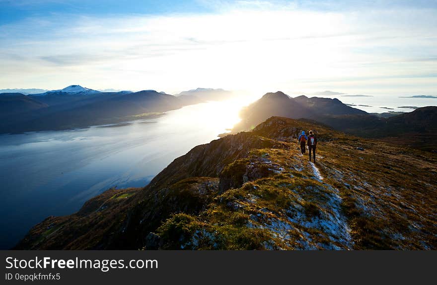 Hikers on the mountain top above a lake at sunrise. Hikers on the mountain top above a lake at sunrise.