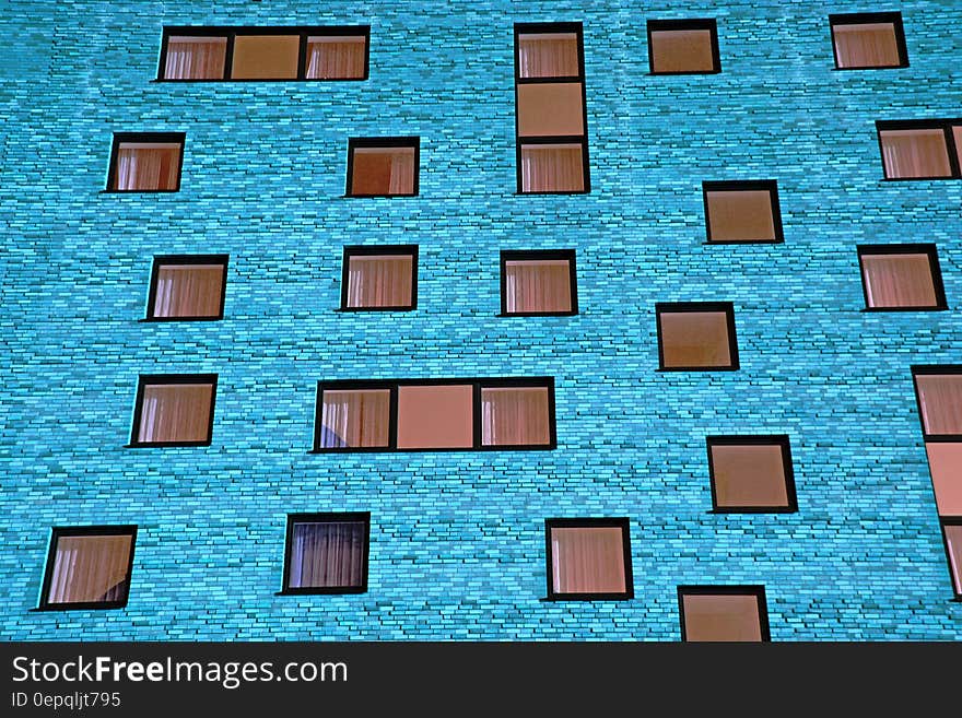 A blue wall of a building with square windows. A blue wall of a building with square windows.