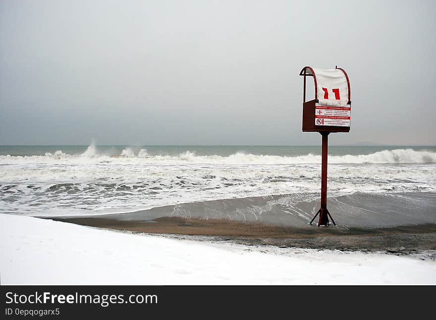 A windy beach with a tower with a "no swimming" notification. A windy beach with a tower with a "no swimming" notification.