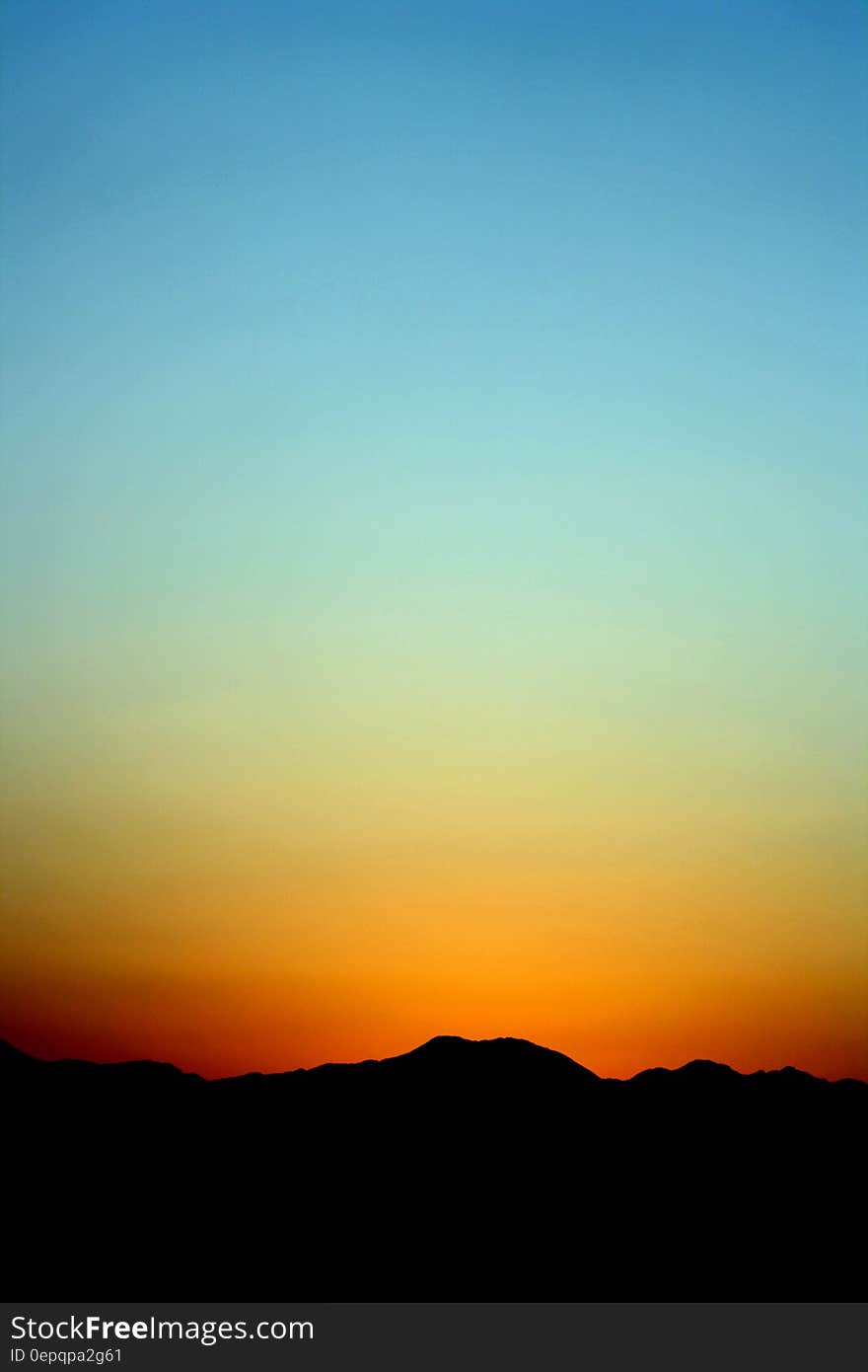 Silhouette of Mountain Under Orange and Blue Sky during Sunset