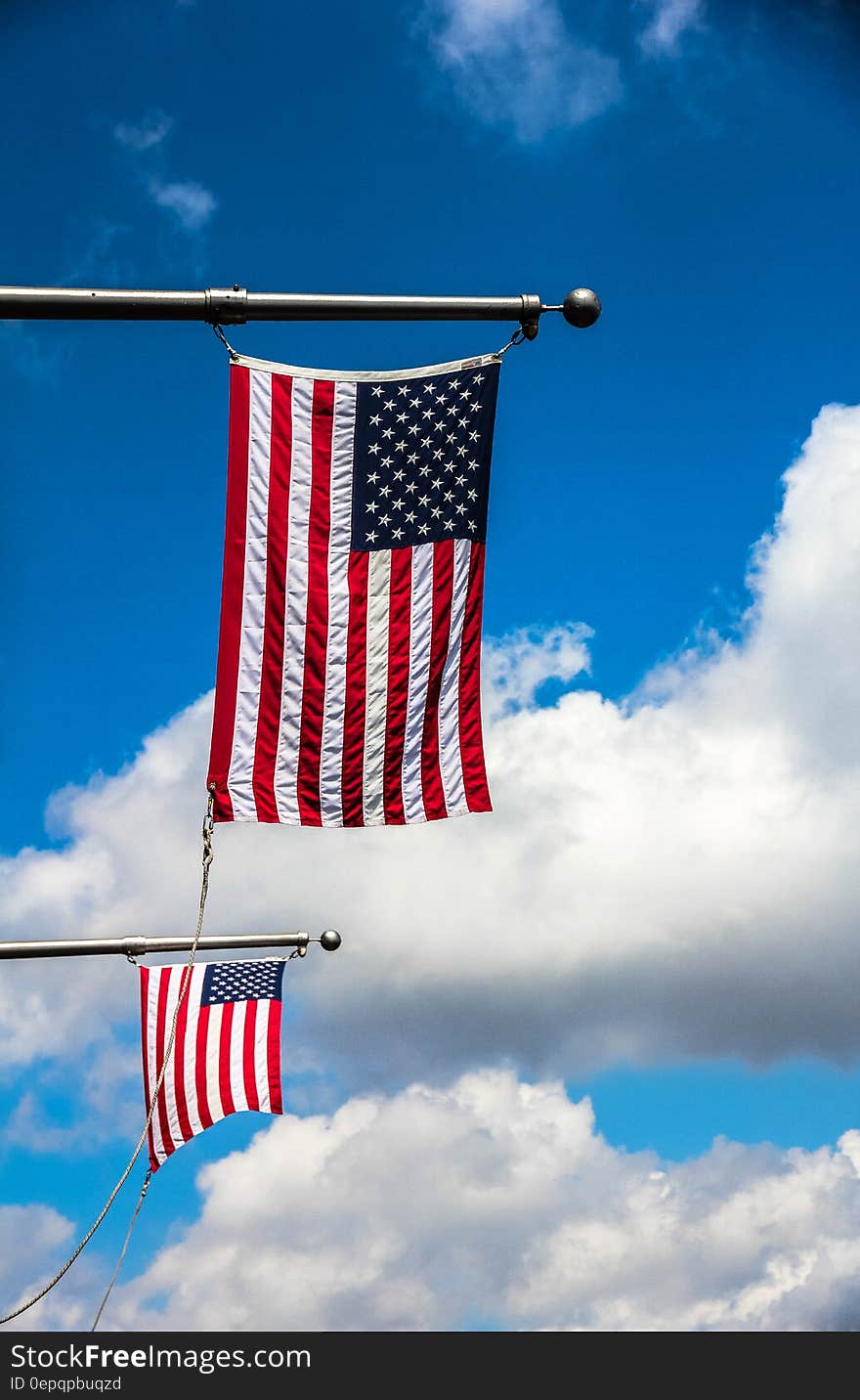 A pair of U.S. flags on horizontal flagpoles. A pair of U.S. flags on horizontal flagpoles.