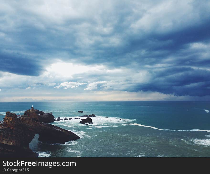 A view over a rocky coast with cloudy skies above. A view over a rocky coast with cloudy skies above.