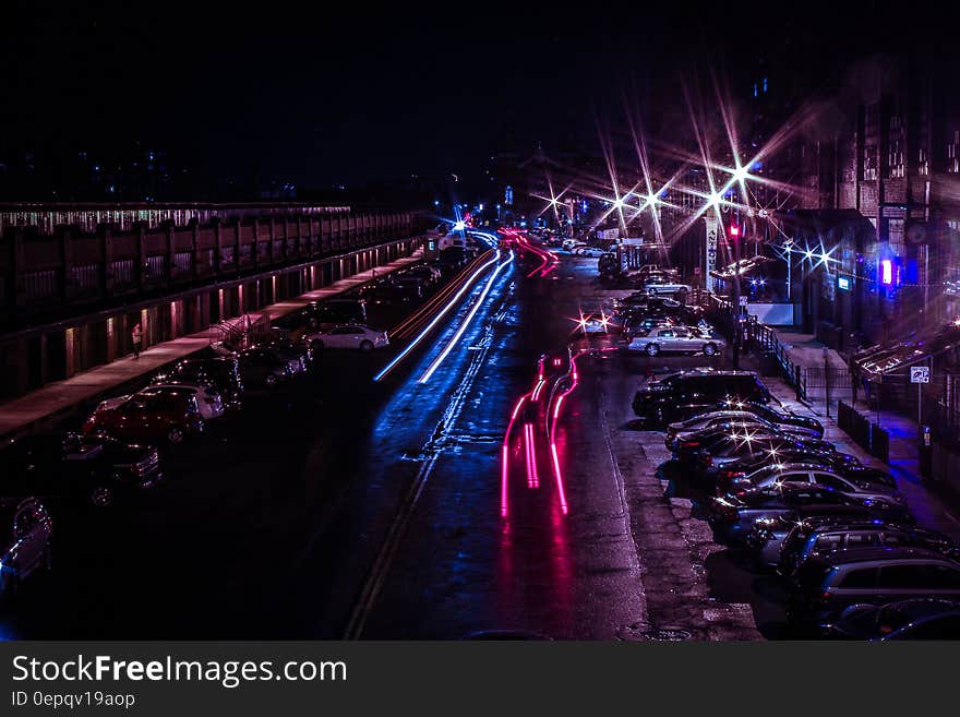 Time Lapse Photo of Cars Passing Near Parking Lot