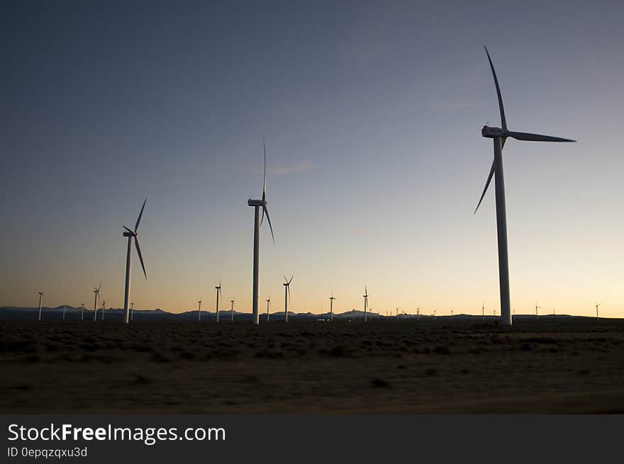 Silhouette of wind turbines in rural field at sunset. Silhouette of wind turbines in rural field at sunset.