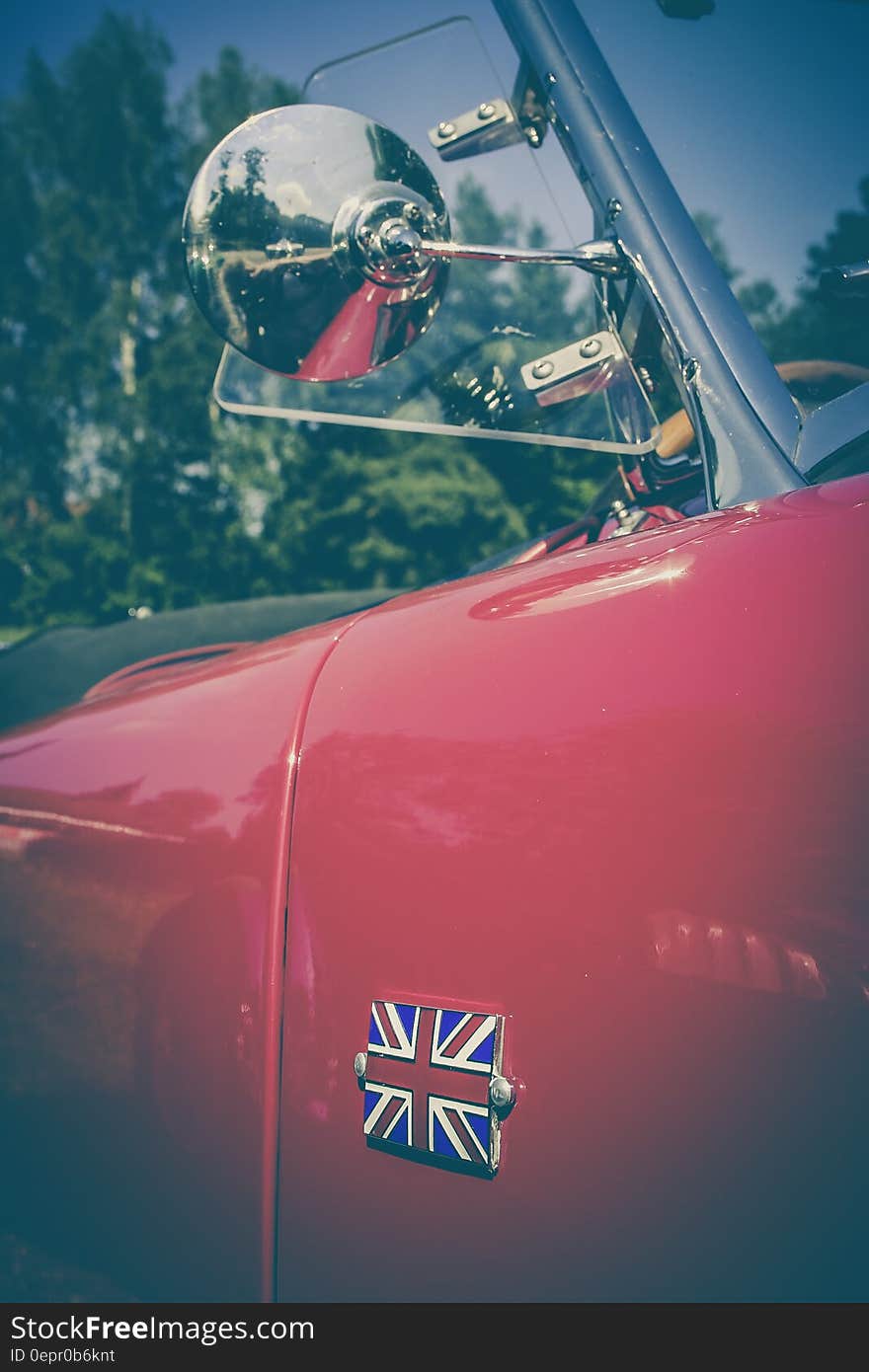 Close up of side door and window on red classic British sports car with flag. Close up of side door and window on red classic British sports car with flag.