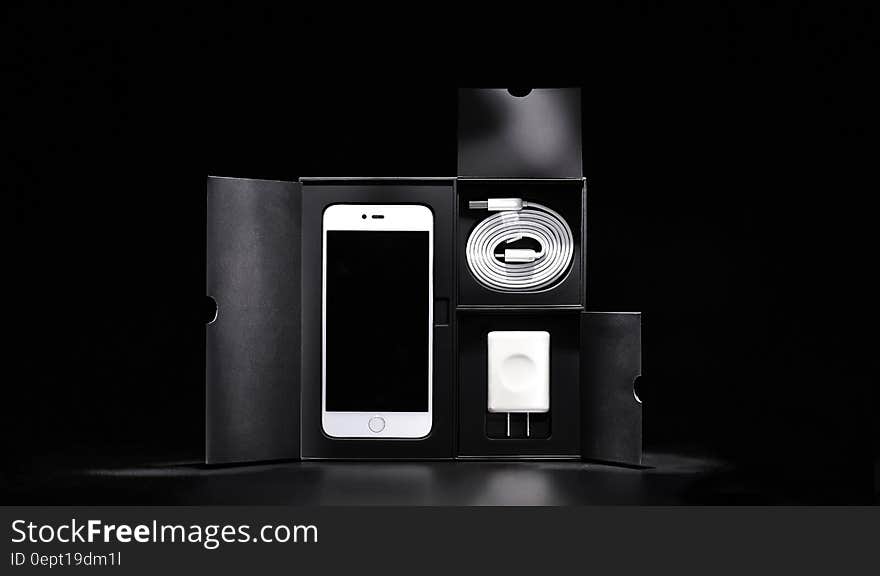 Close up of new smartphone and accessories in block in black and white. Close up of new smartphone and accessories in block in black and white.