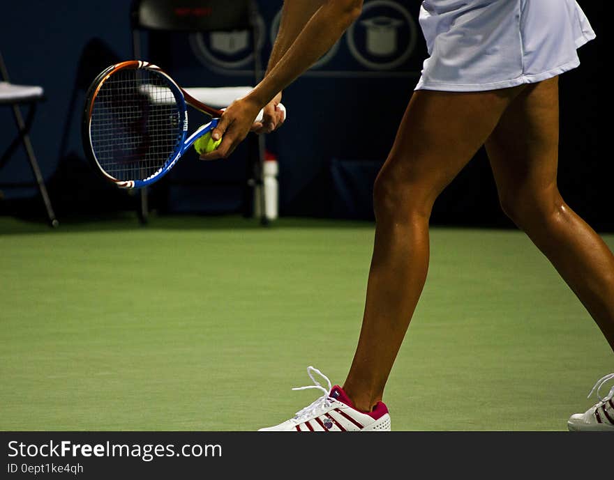 Female tennis player with racket and ball ready to serve on grass court. Female tennis player with racket and ball ready to serve on grass court.