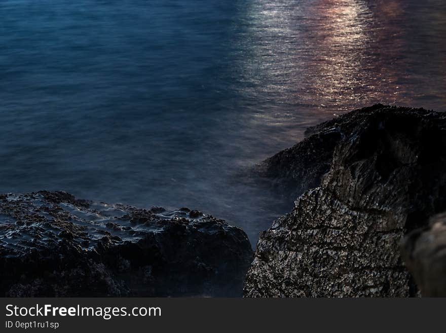 Sunset over waves washing on rocks along coastline. Sunset over waves washing on rocks along coastline.