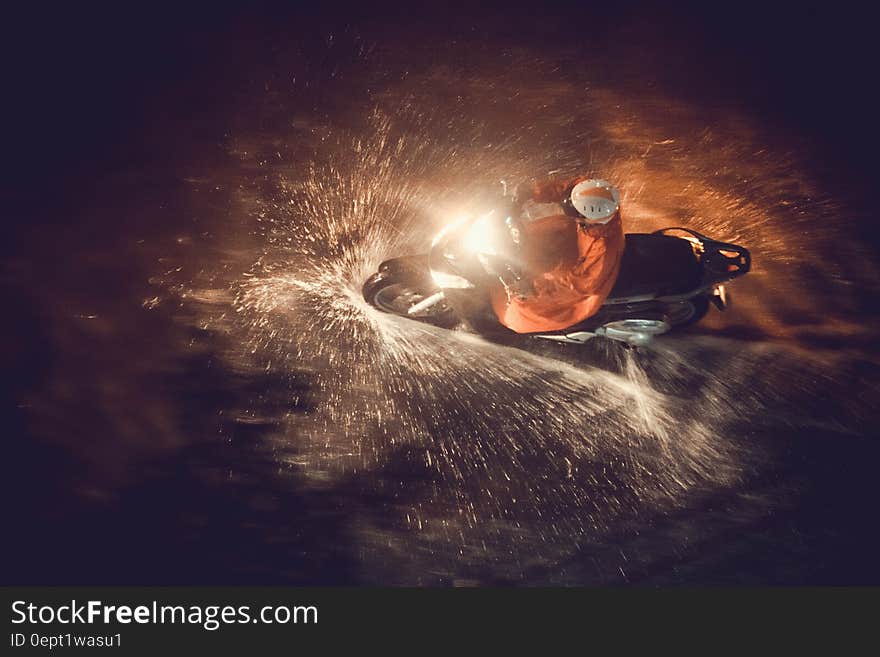 Motorcycle rider driving through water with headlight in dark. Motorcycle rider driving through water with headlight in dark.