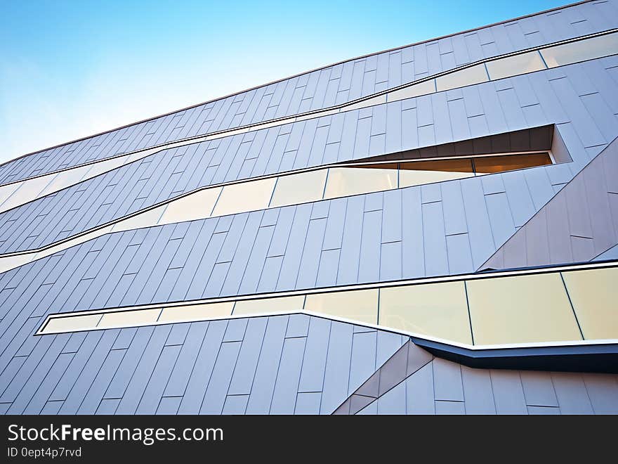 Panels and windows on facade of modern building against sunny days.