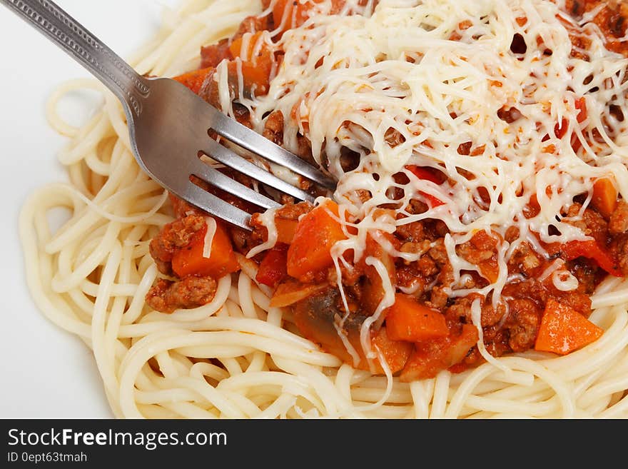 A portion of ragu sauce spaghetti with grated cheese on top.