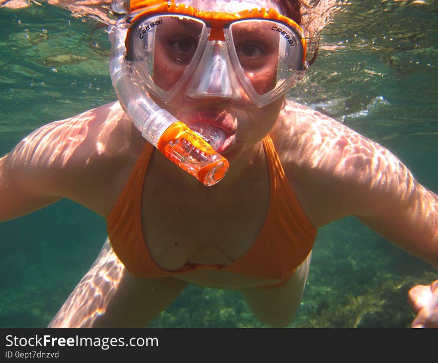 Woman in Orange Bikini Underwater With Snorkel