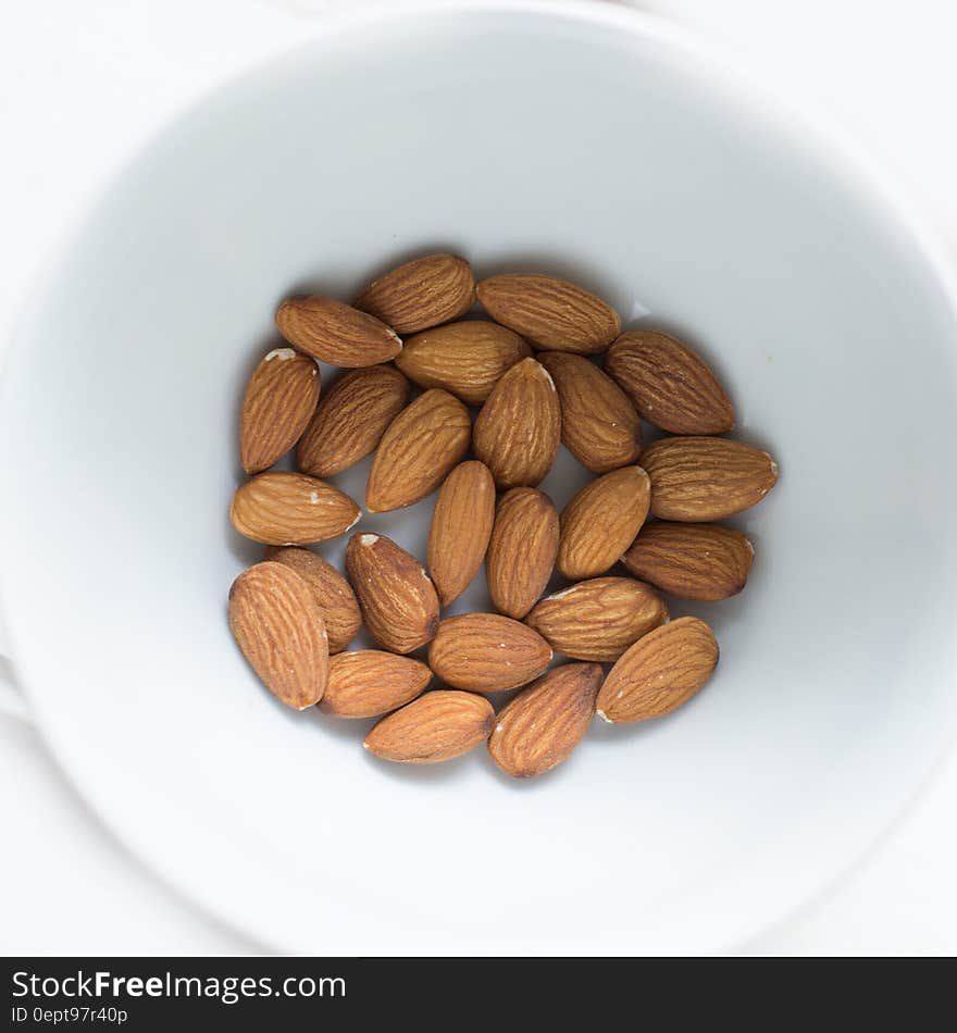 Bowl of almonds isolated on white.