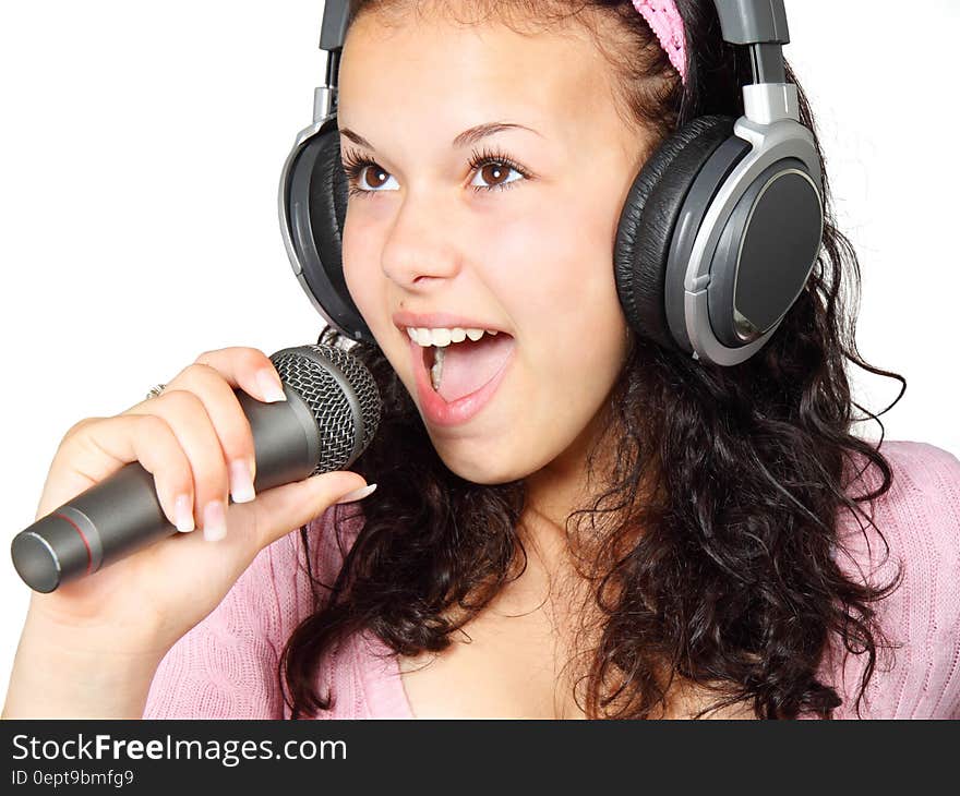 A Girl Holding a Microphone With a Headphone