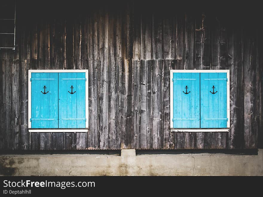 Blue wooden window shutters with anchor signs. Blue wooden window shutters with anchor signs.