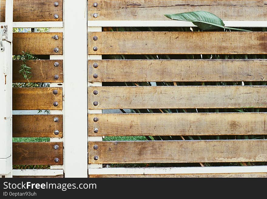 A close up shot of a wooden fence with white metal frame.