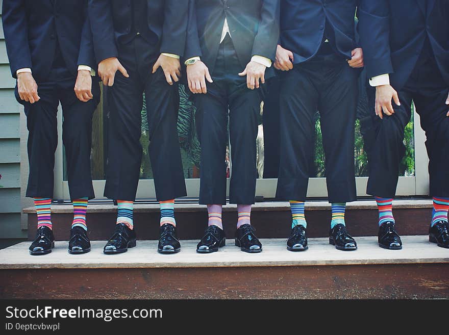 Businessmen standing on steps with colorful striped socks under suits. Businessmen standing on steps with colorful striped socks under suits.