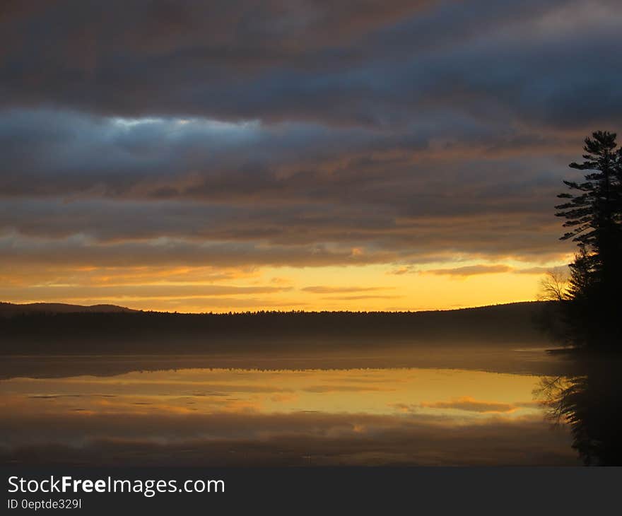 A sunrise is reflected over a lake. A sunrise is reflected over a lake.