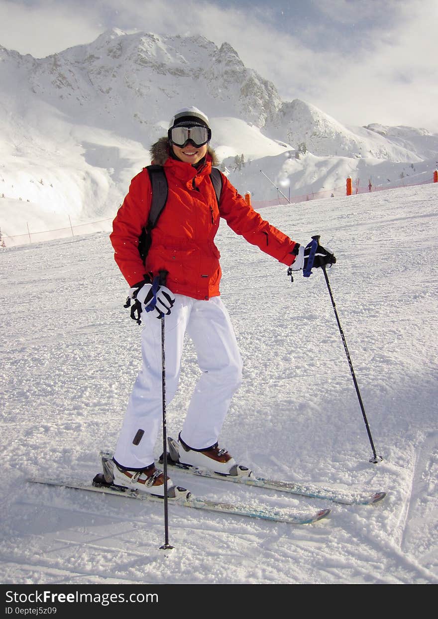 Woman in Red Jacket and White Pants on White Snow