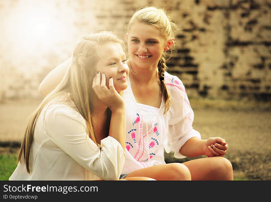 Two Women Sitting Down Smiling