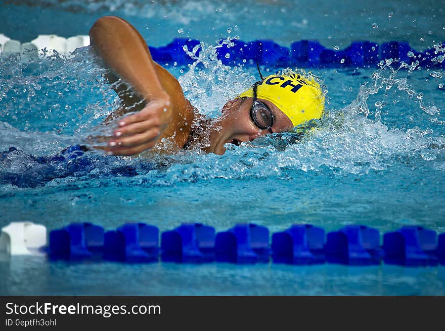 Person Wearing Yellow Swimming Cap on Swimming Pool