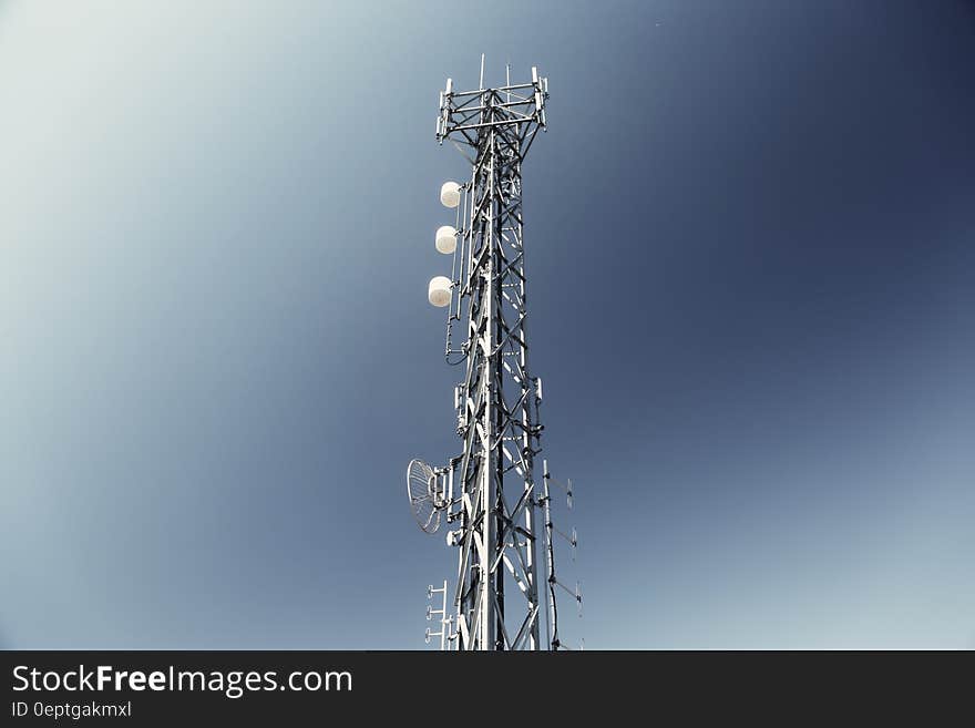 Television transmission tower with blue and white sky background.