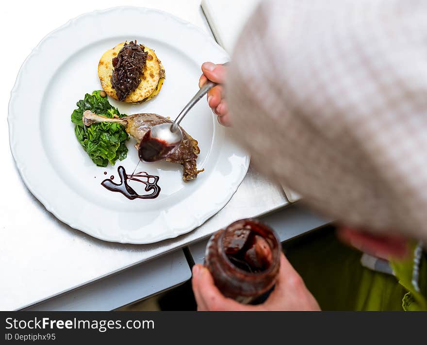 Green Salad Caviar on Beige Pancake Garnished With Chocolate Syrup on White Round Ceramic Dining Plate