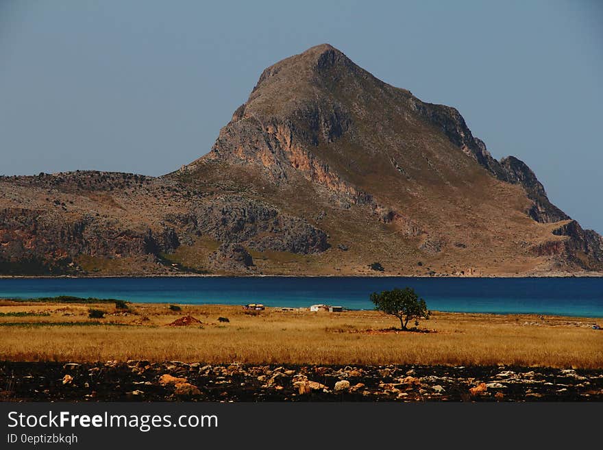 Grey and Brown Rock Formation Near Calm Water Photo