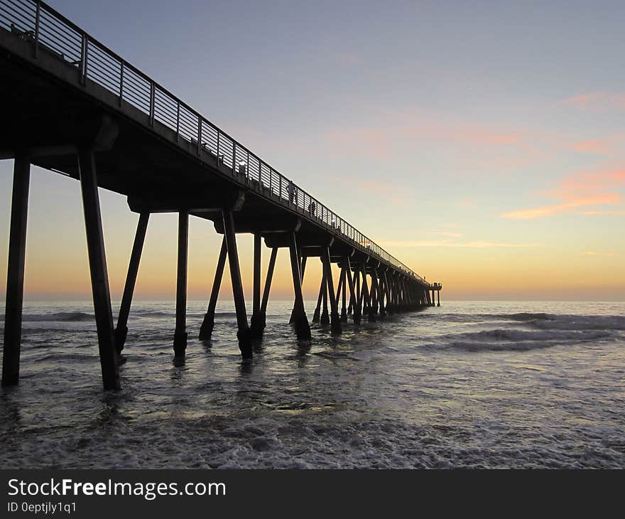 Wooden pier in ocean waves at sunrise. Wooden pier in ocean waves at sunrise.