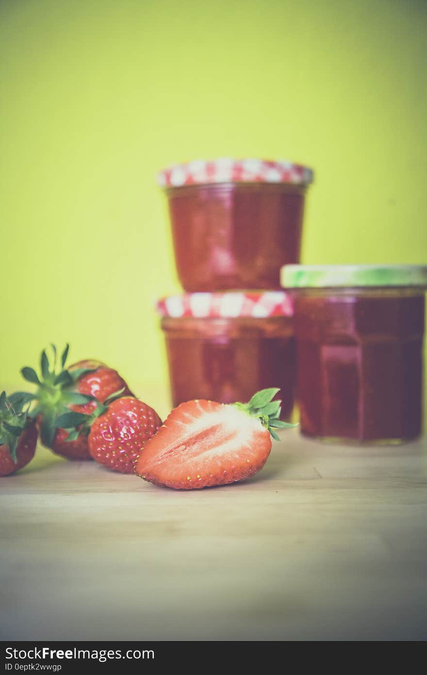 Strawberry Near Red Jar on Wooden Surface