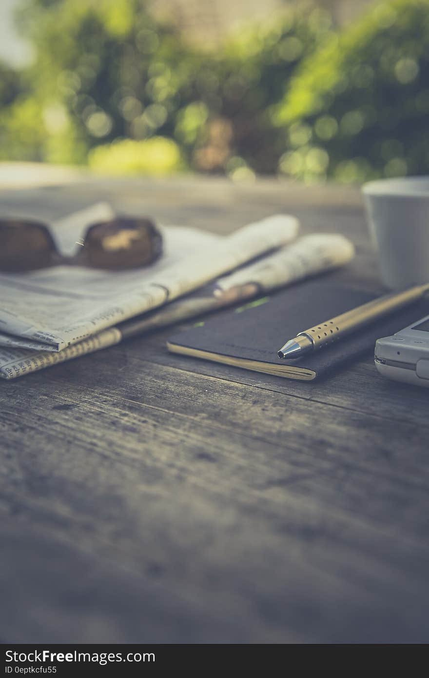 Silver Click Pen on Brown Wooden Table during Daytime