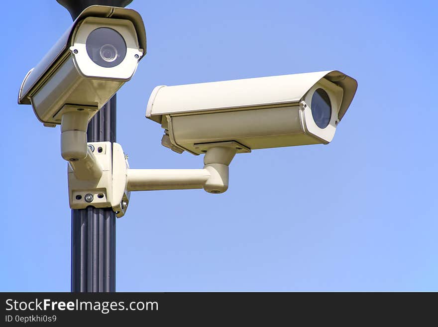 White 2 Cctv Camera Mounted on Black Post Under Clear Blue Sky