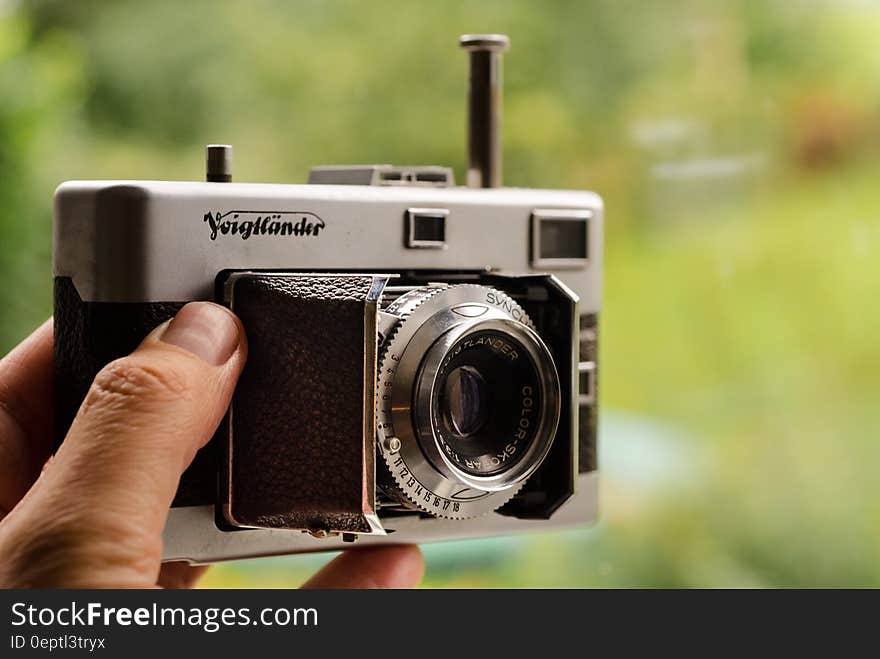 Hand holding vintage analog camera outdoors on sunny day. Hand holding vintage analog camera outdoors on sunny day.