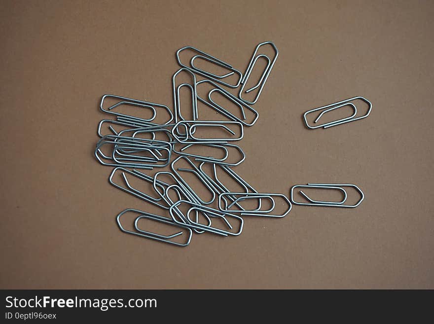 Gray Paper Clip on Brown Table