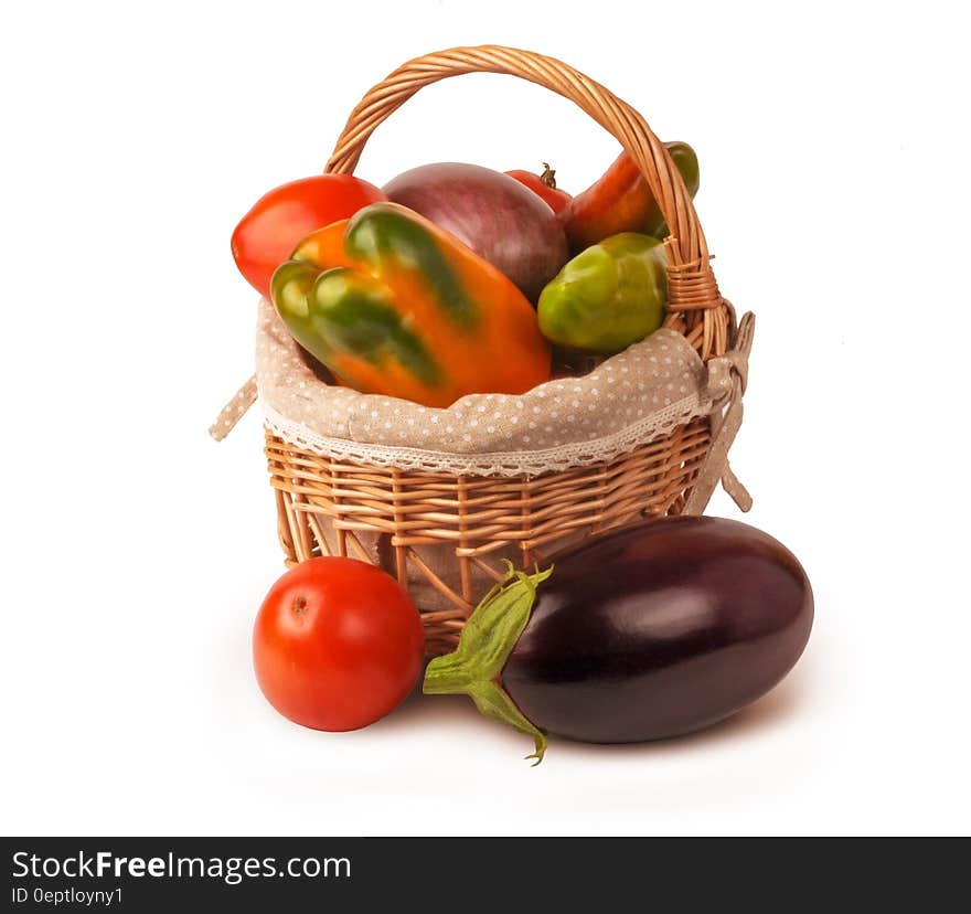 Wicker basket with fresh vegetables on white. Wicker basket with fresh vegetables on white.