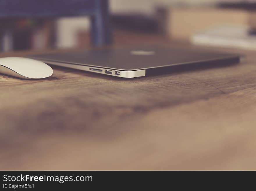 A laptop and a mouse on a wooden desk. A laptop and a mouse on a wooden desk.