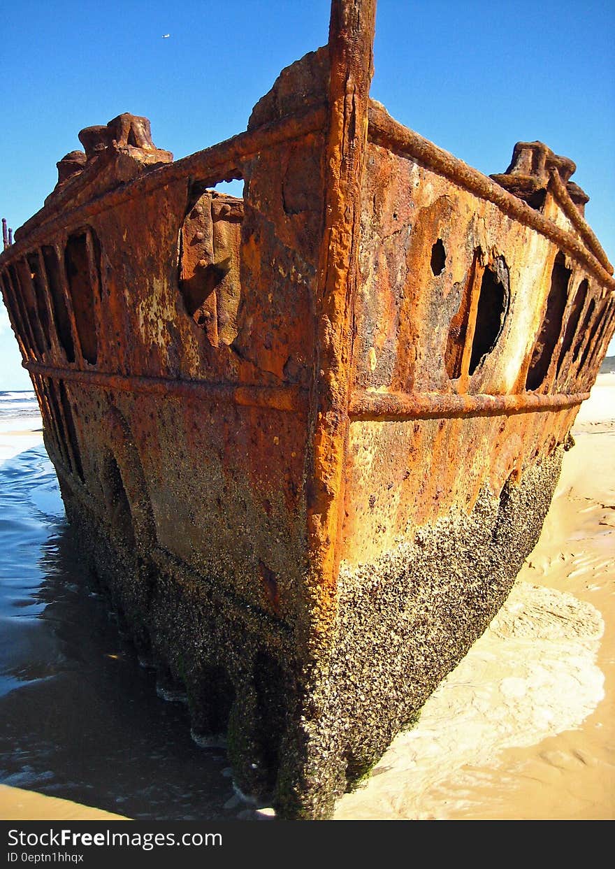 Brown Metal Shipwreck on Seashore during Daytime