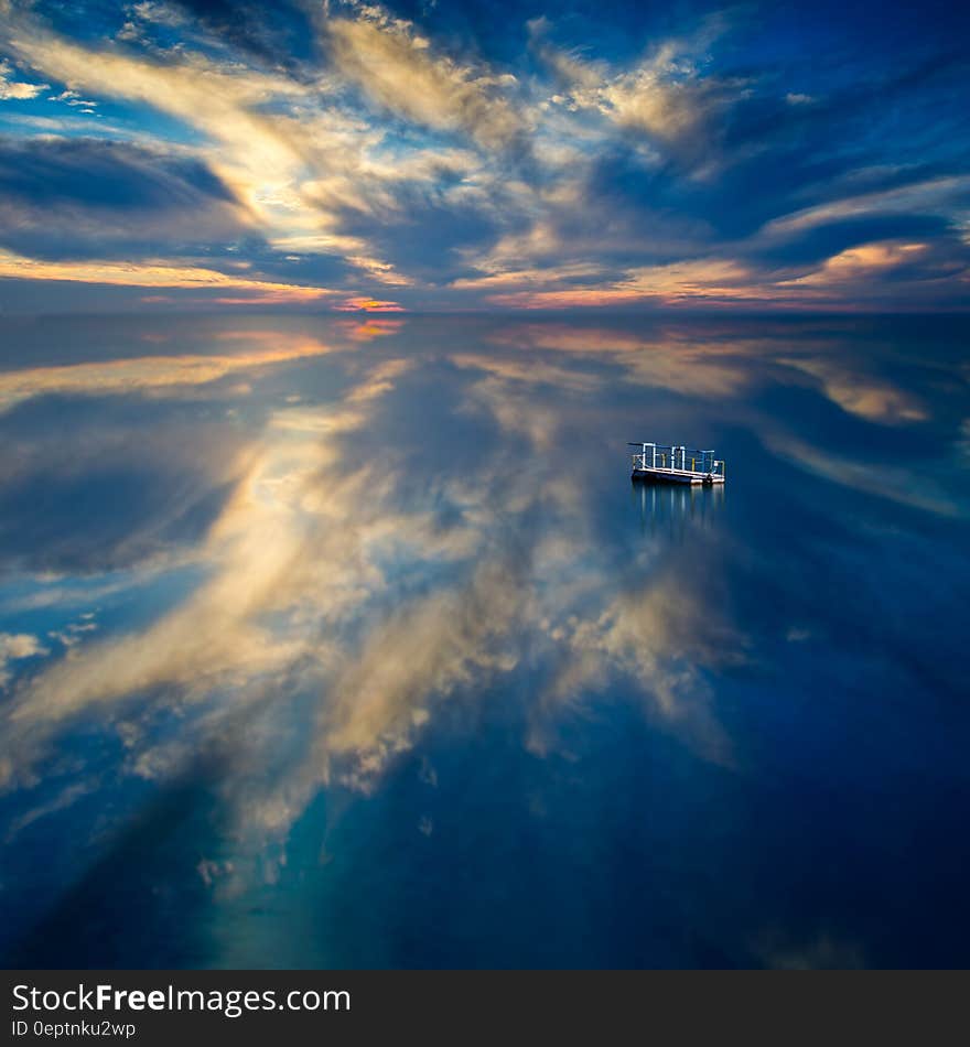 Blue waters with raft reflecting clouds and colors at sunset. Blue waters with raft reflecting clouds and colors at sunset.