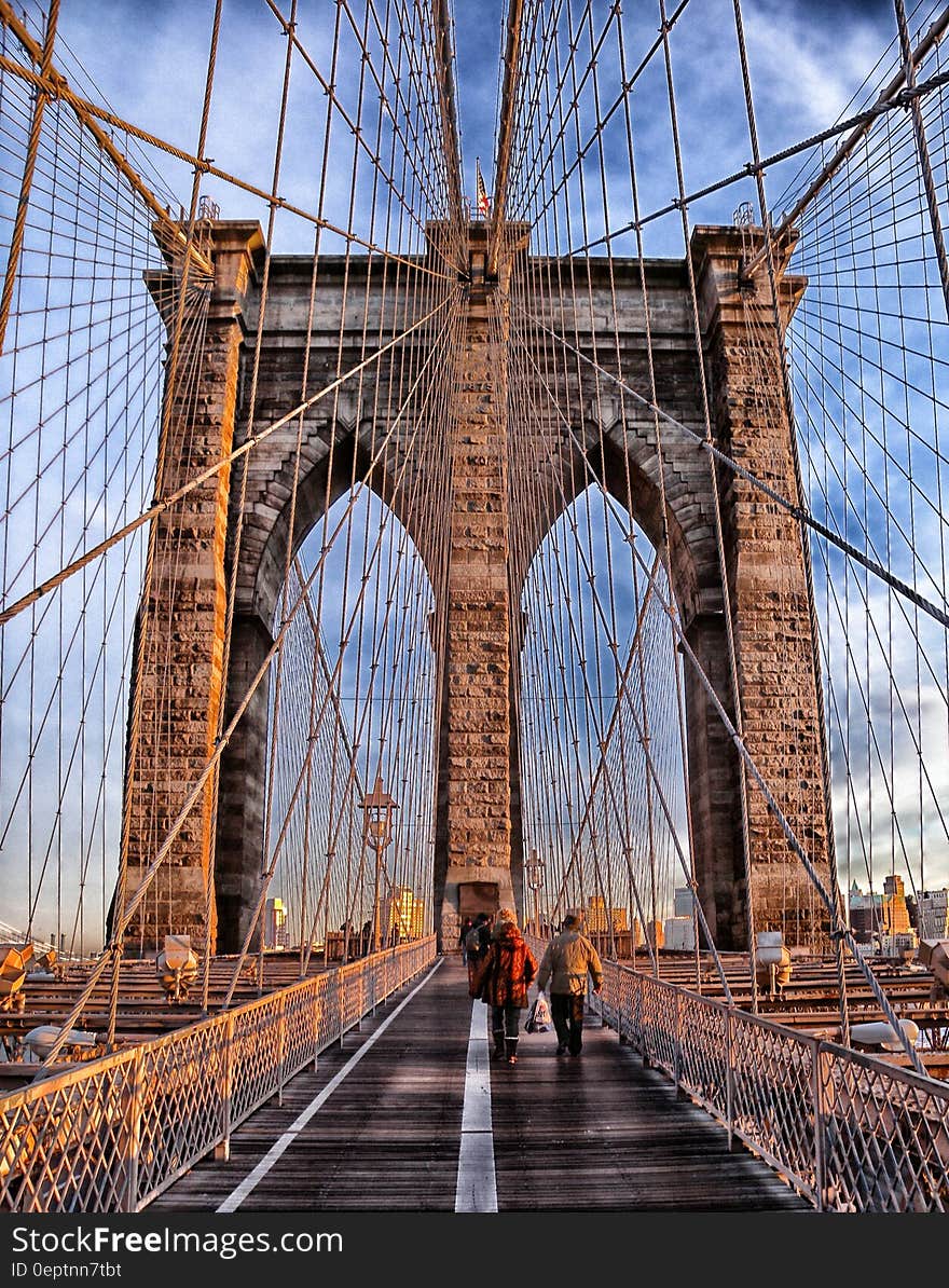 Two Person Walking on Bridge during Daytime