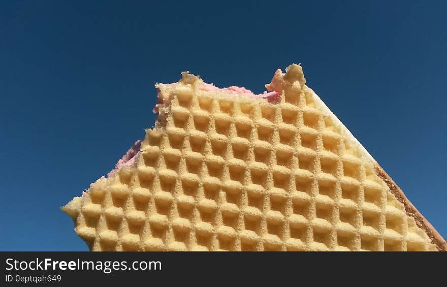 An ice cream sandwich with waffles against the blue skies.