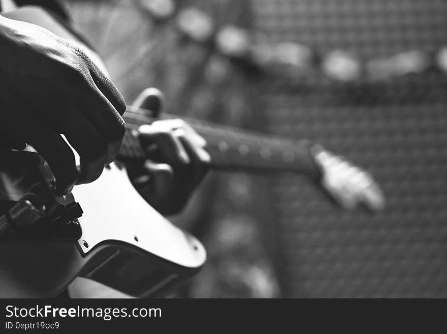 Grayscale Photo of Person Holding Electric Guitar