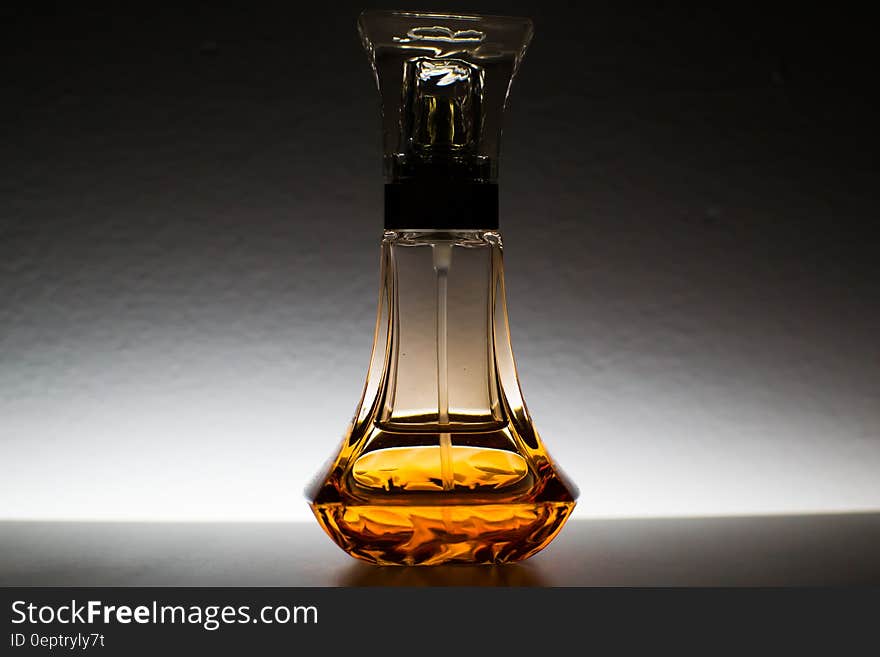 Close up of decorative perfume bottle with amber liquid.