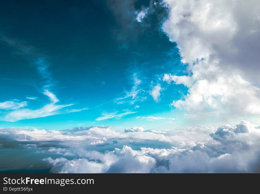 White clouds in blue skies over horizon on sunny day.