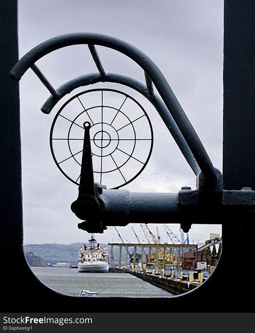 Window looking out over ship in port on sunny day. Window looking out over ship in port on sunny day.