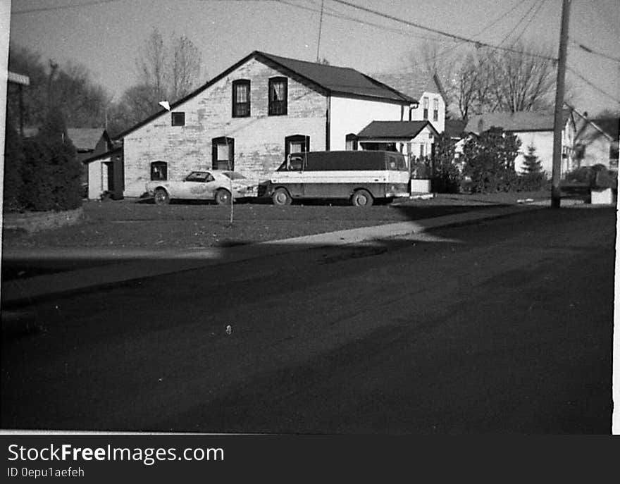 Car and van parked outside home in Belleville circa 1970 in black and white. Car and van parked outside home in Belleville circa 1970 in black and white.