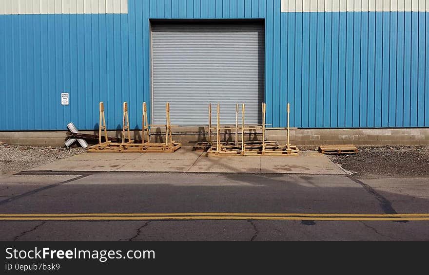 Wood pallets outside closed loading dock on industrial building. Wood pallets outside closed loading dock on industrial building.