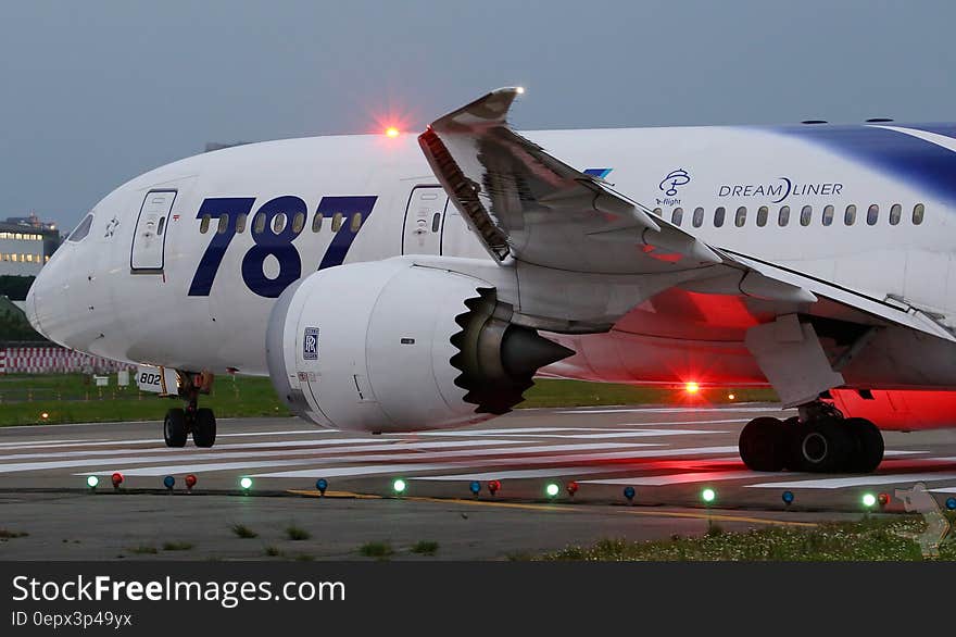 Boeing 787 Dreamliner on runway at twilight.