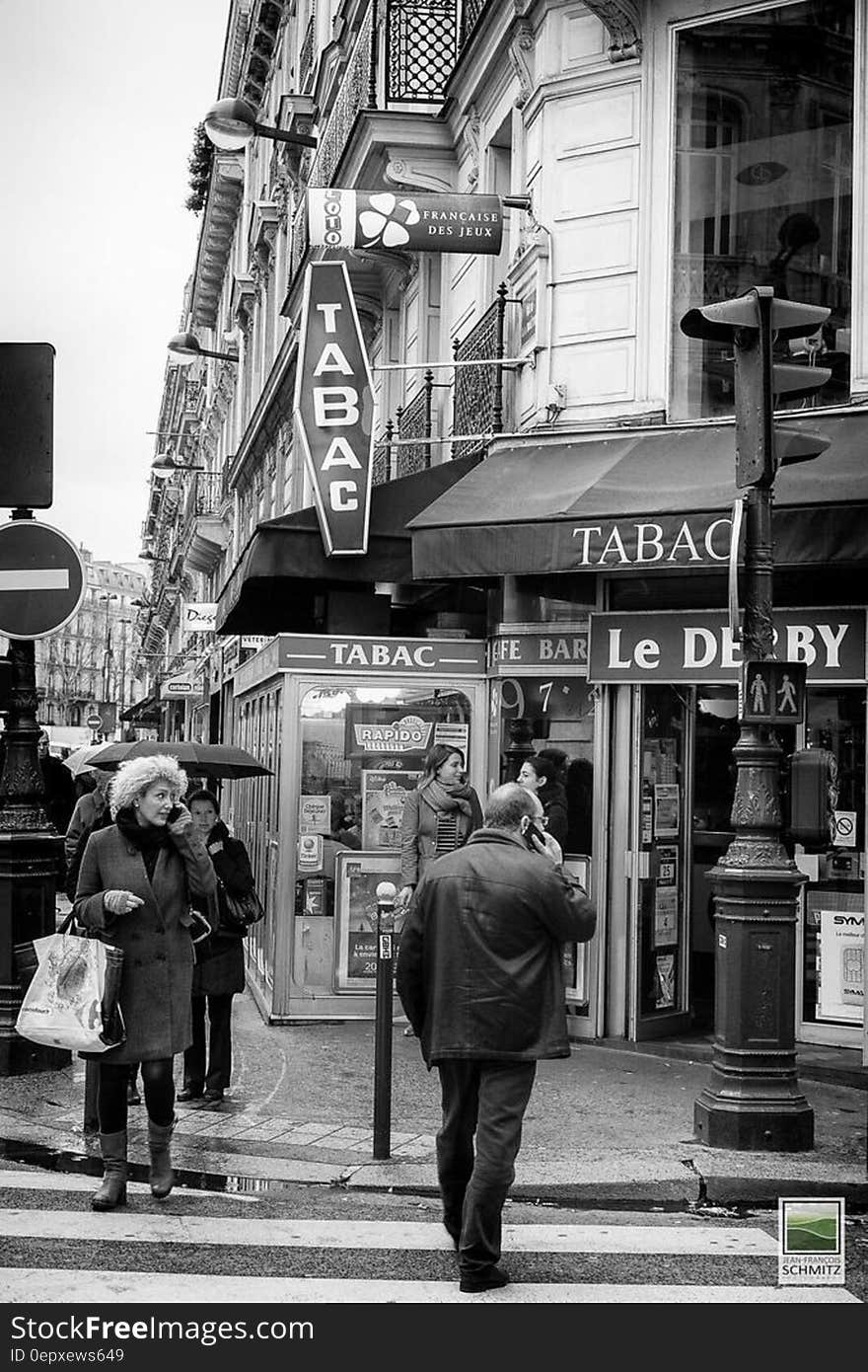 Pedestrians on French street outside shops in black and white. Pedestrians on French street outside shops in black and white.