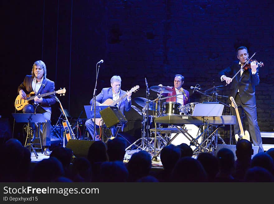 Musicians playing instruments onstage in concert. Musicians playing instruments onstage in concert.